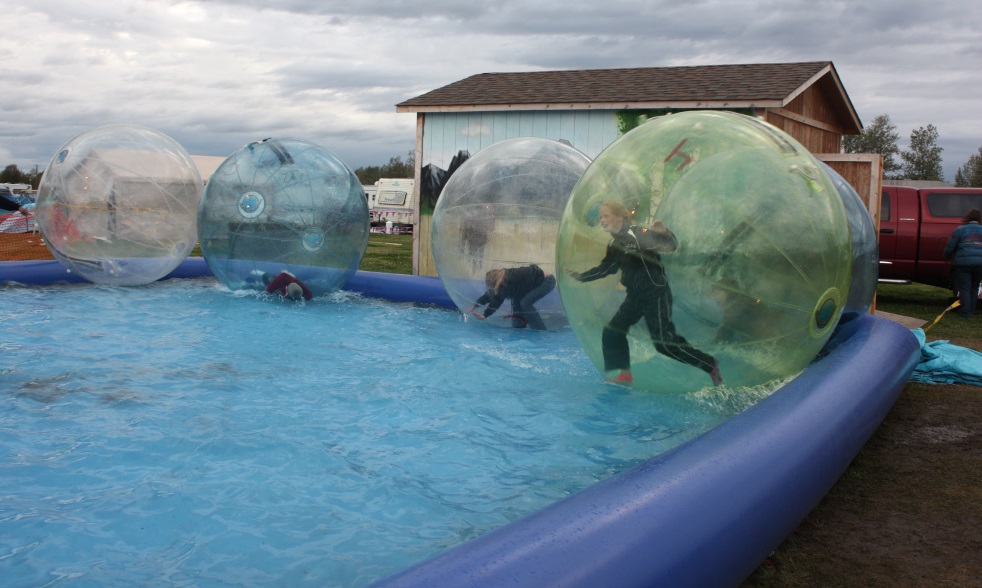 Attempting to maneuver their inflated balls around the pond